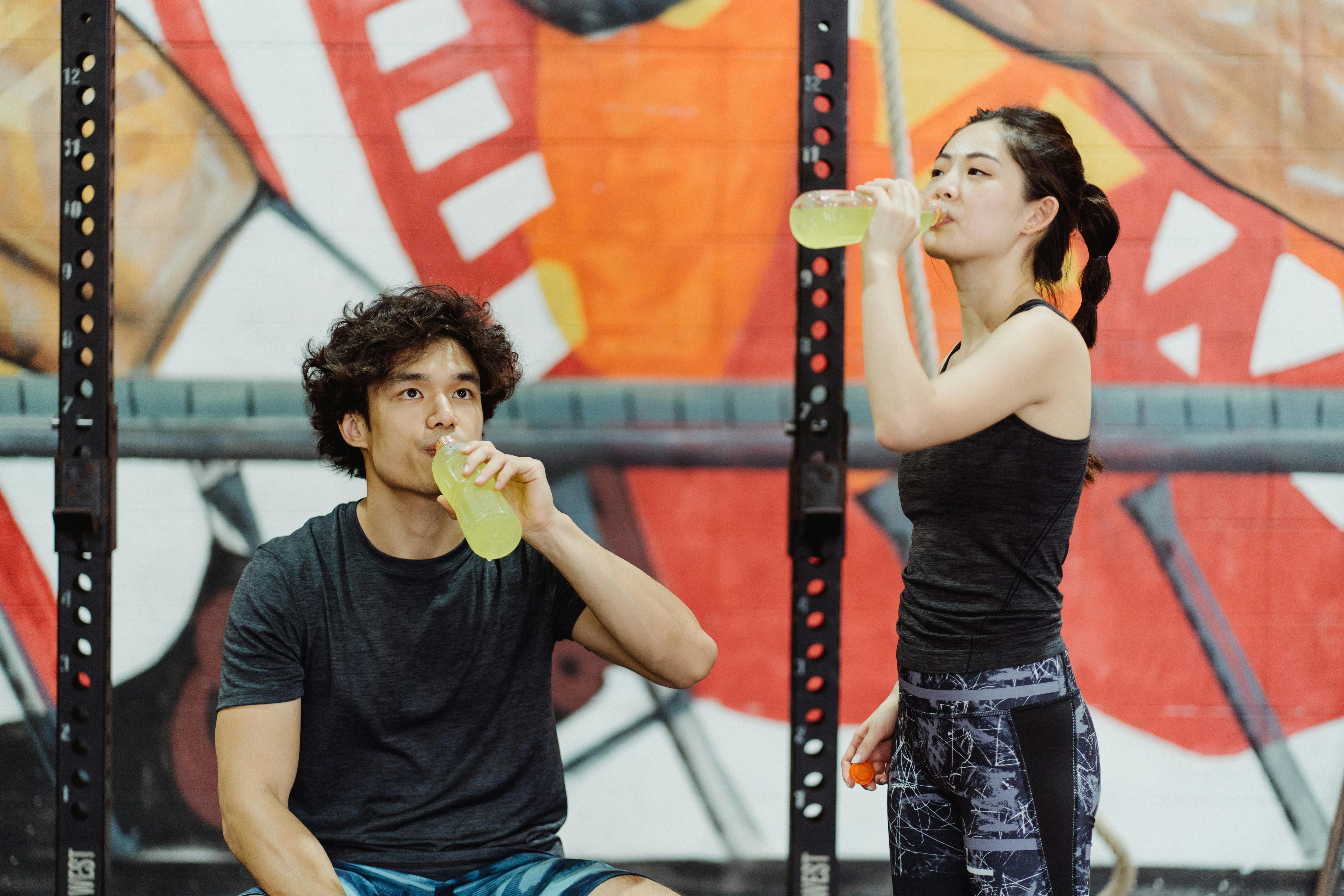 An active couple enjoying electrolyte drinks after a workout, helping to replenish hydration and boost recovery naturally.