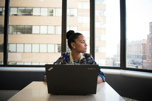 A woman using CBT techniques to manage career-related stress, balancing work responsibilities and self-care.