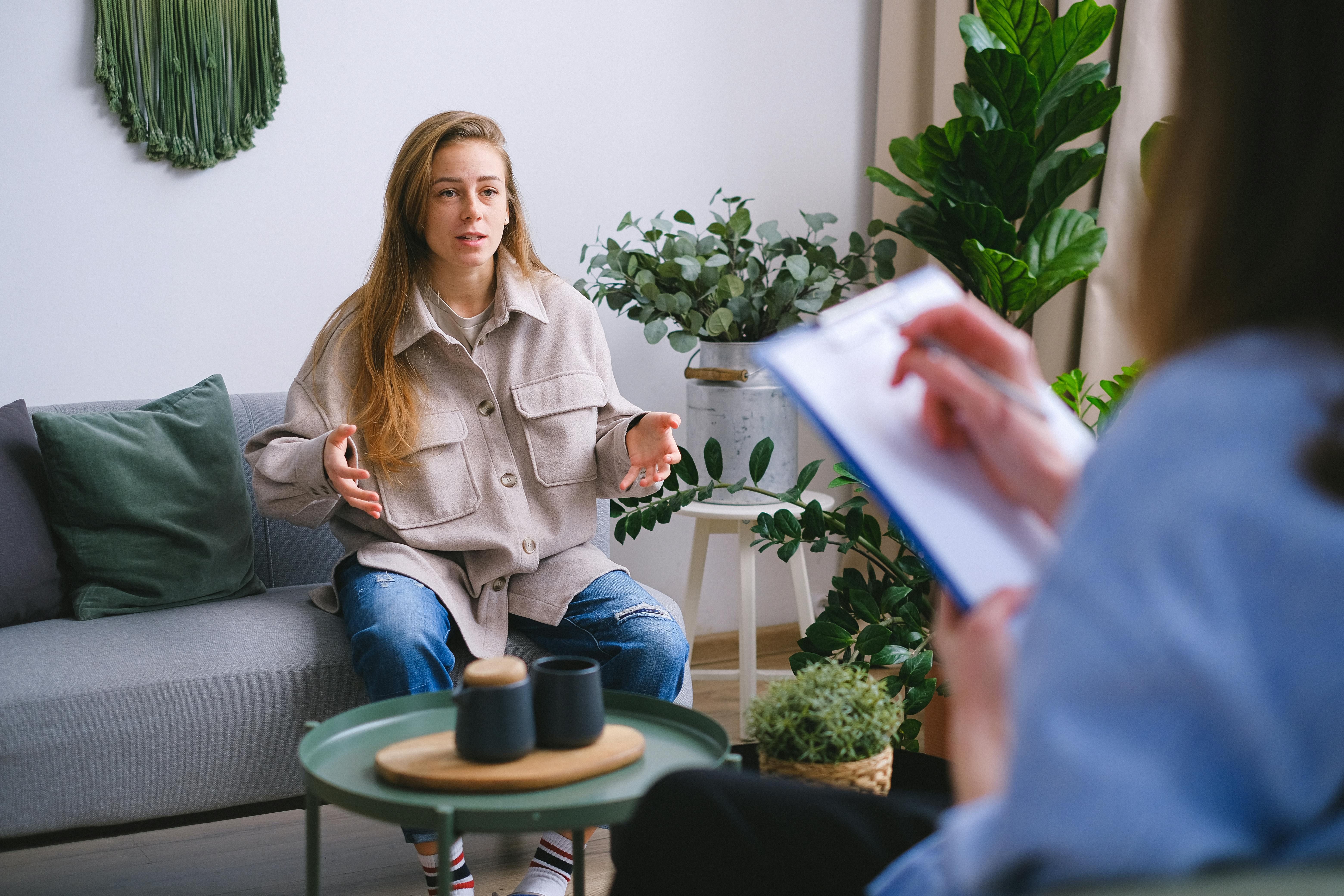 A woman attending a CBT session for PTSD, working with a therapist to process trauma and develop coping strategies.