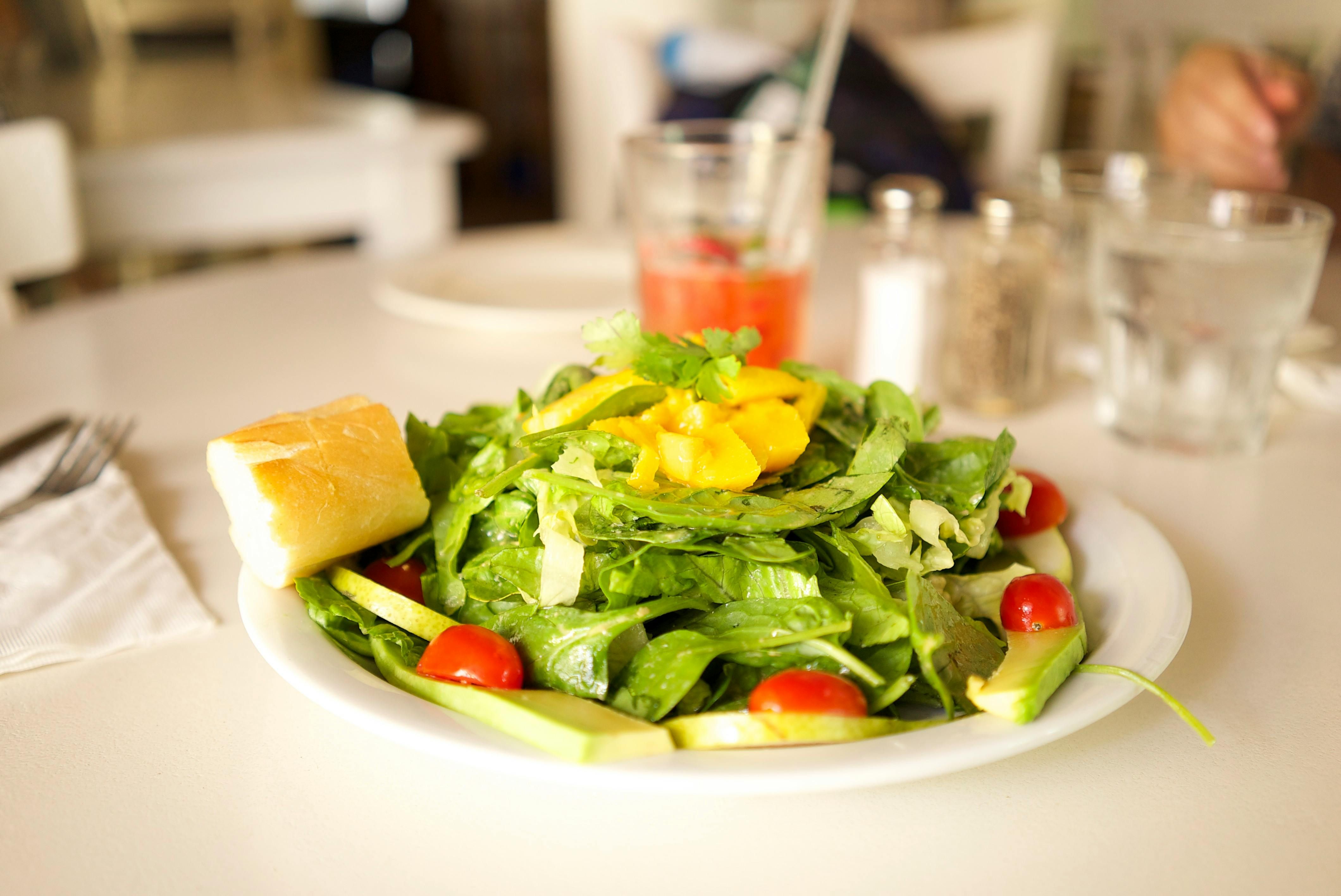 A freshly prepared healthy salad featuring mixed greens, colorful vegetables, and a sprinkle of seeds on a light background.