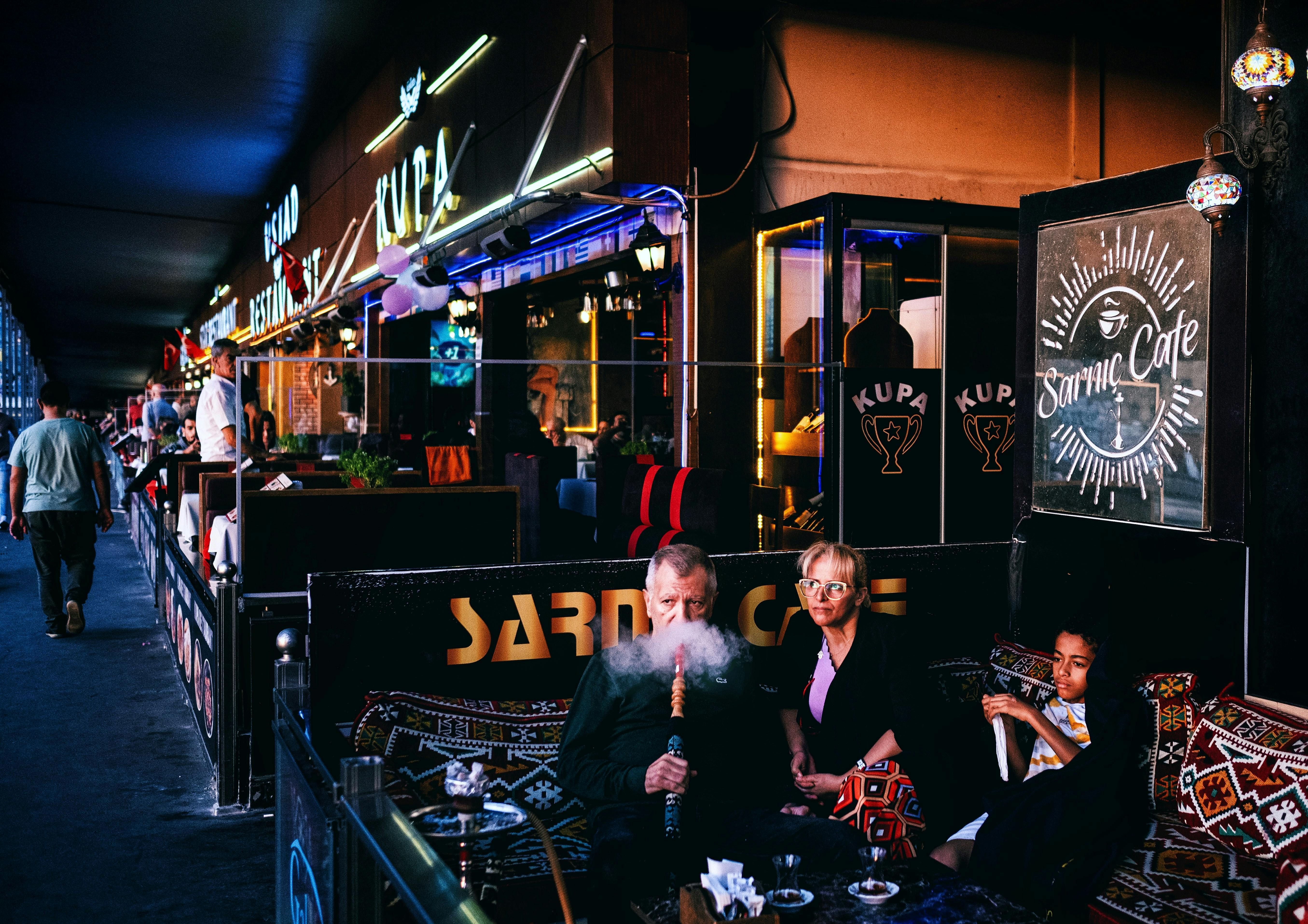 Group of people smoking hookah, unaware of the health risks like respiratory issues, cancer, and infectious diseases.