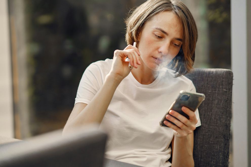 A woman experiencing the harmful effects of vaping, highlighting risks like lung damage, reproductive health issues, and heart disease.