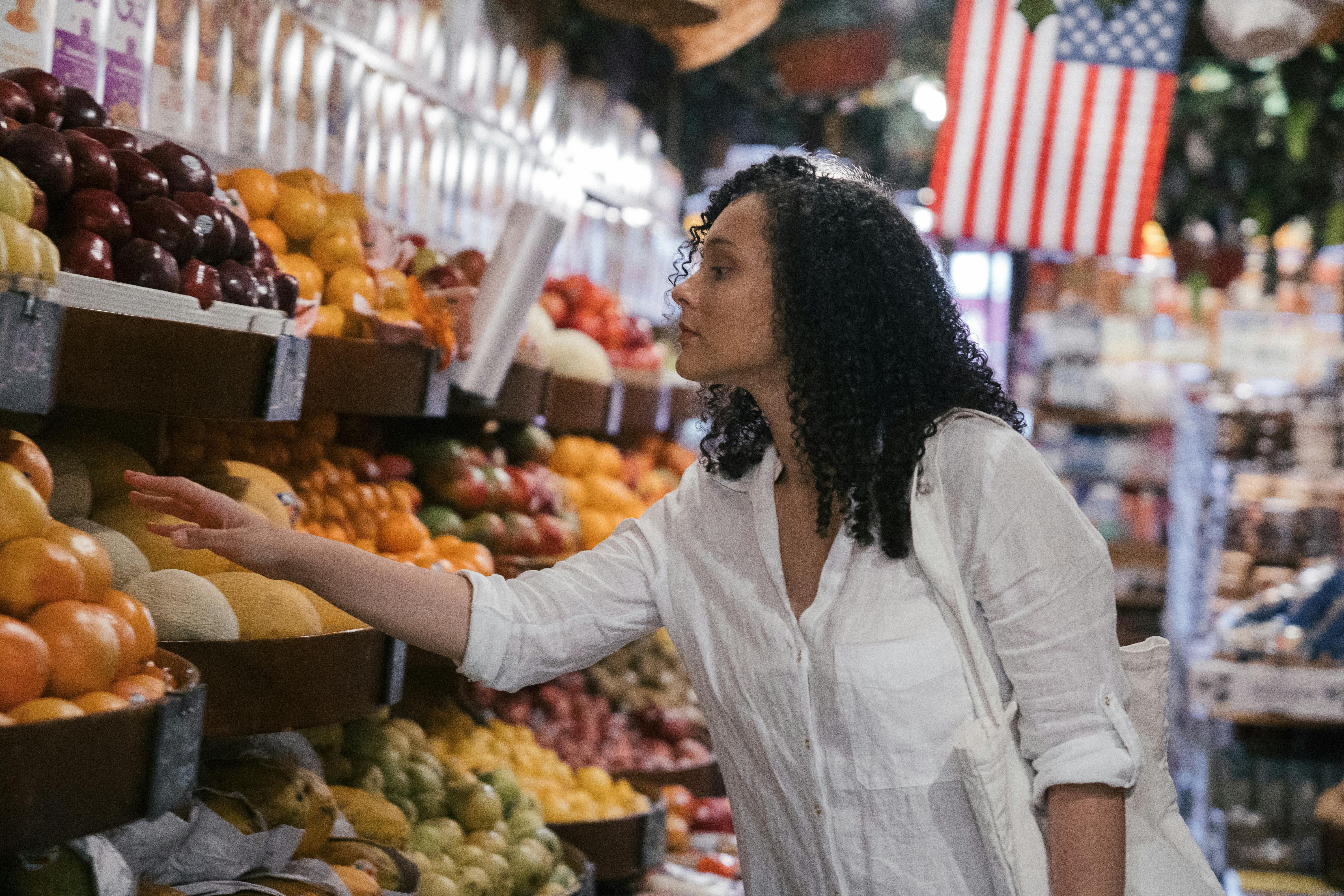 A woman choosing mood-boosting, nutrient-rich foods in a supermarket to support emotional well-being.