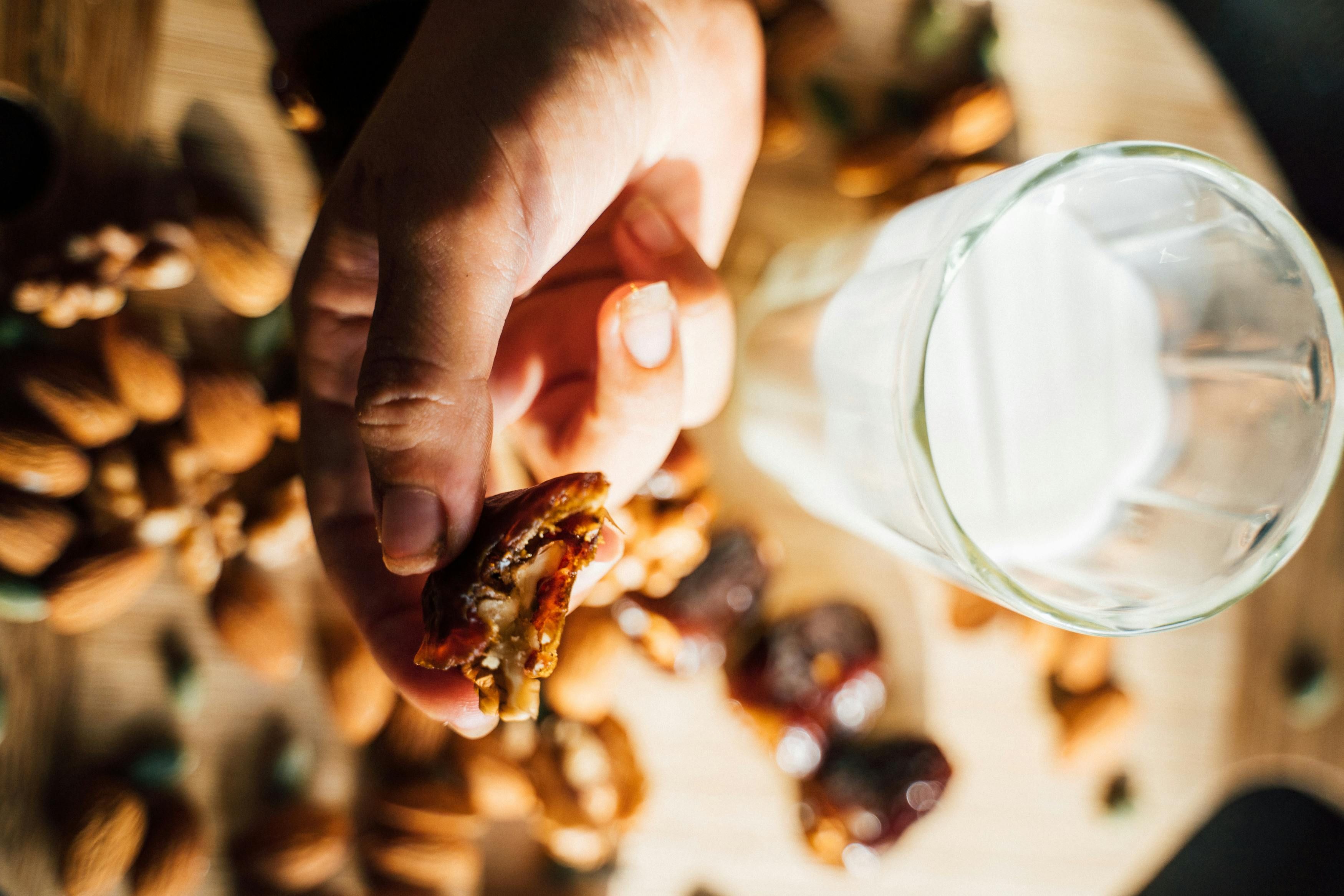 A woman enjoying a glass of plant-based milk with dates, benefiting from natural sweetness and nutritional wellness.