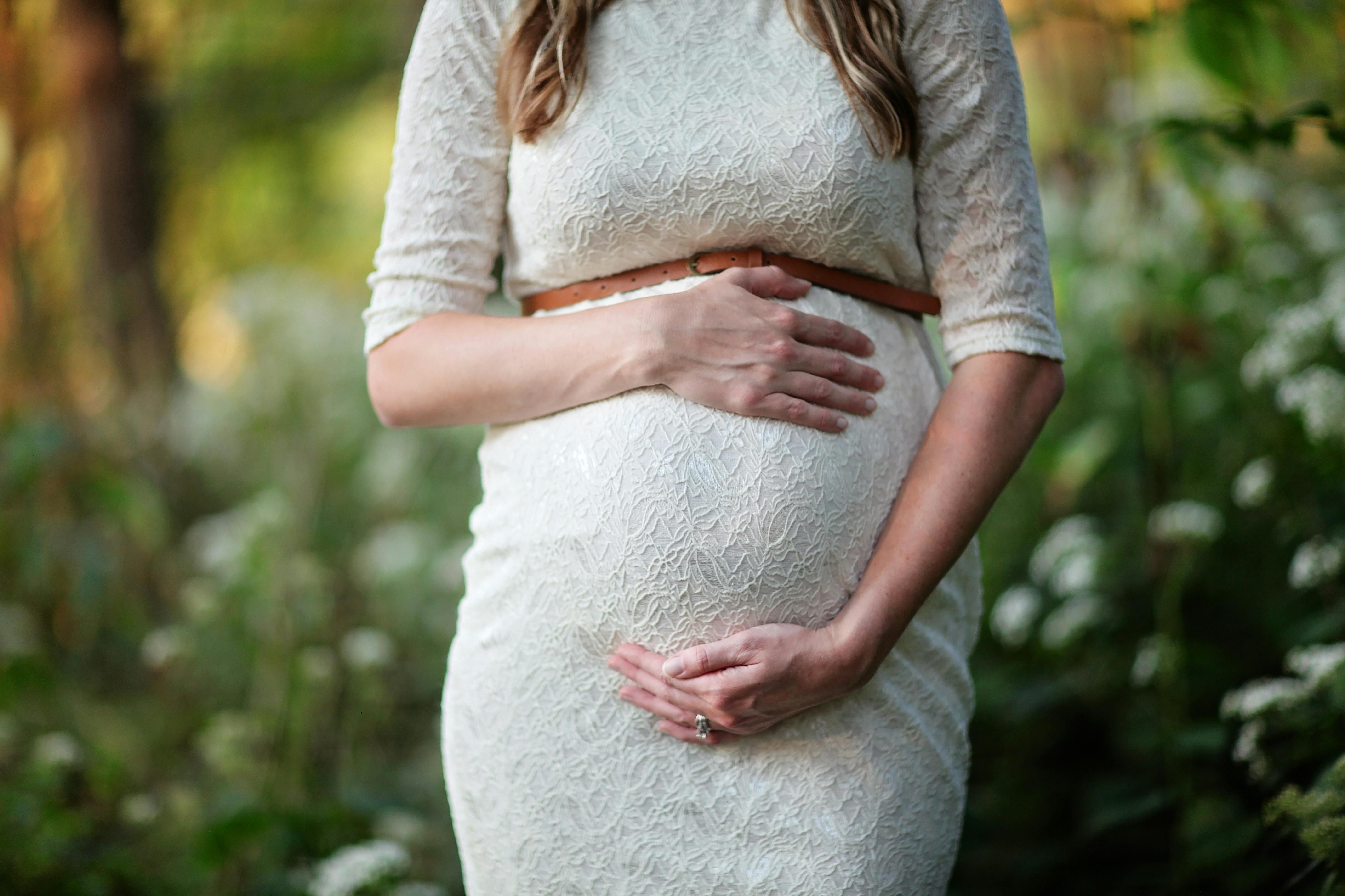 A joyful pregnant woman embracing her pregnancy, radiating happiness and health.