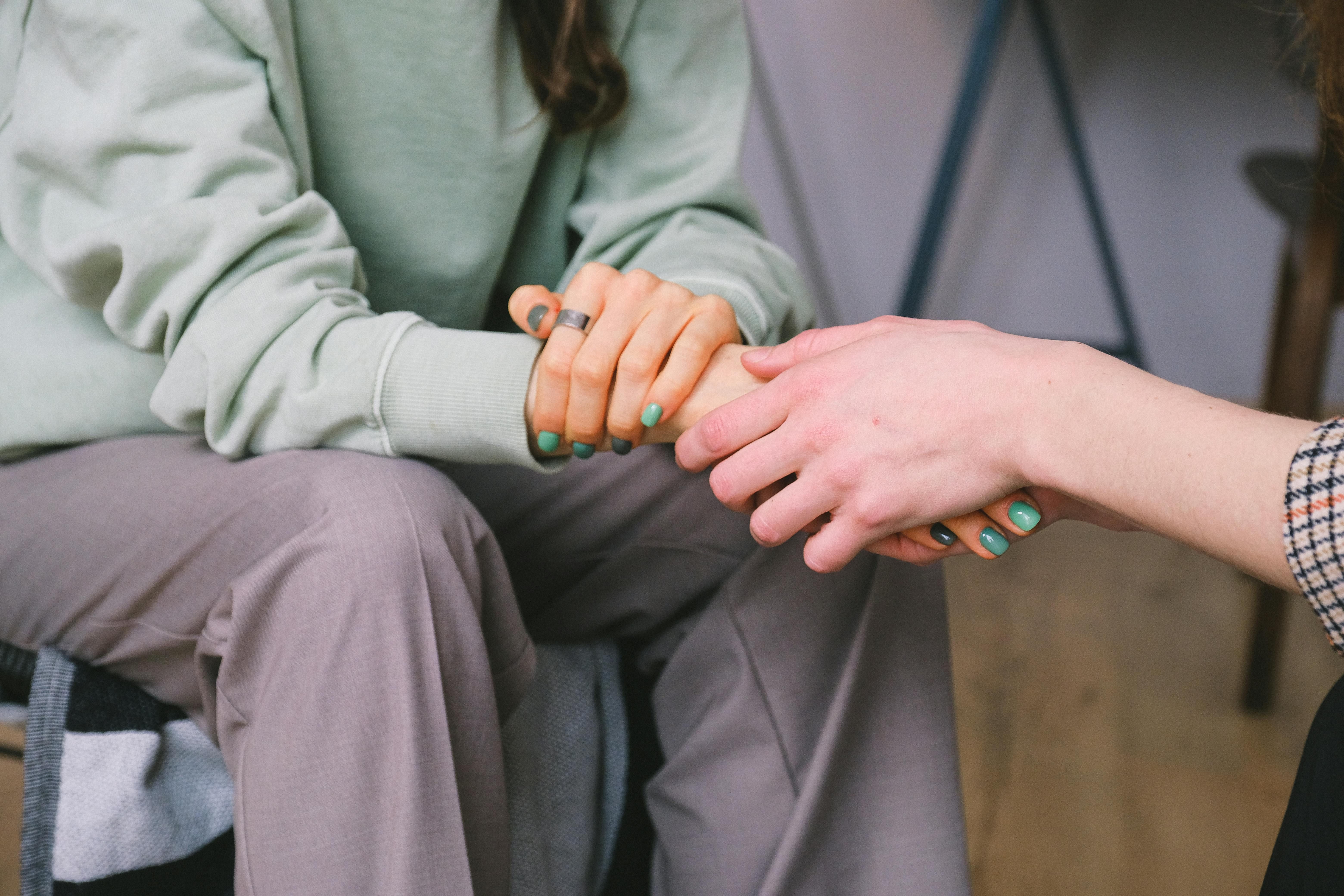 Client and counselor holding hands, symbolizing support in weight loss counseling