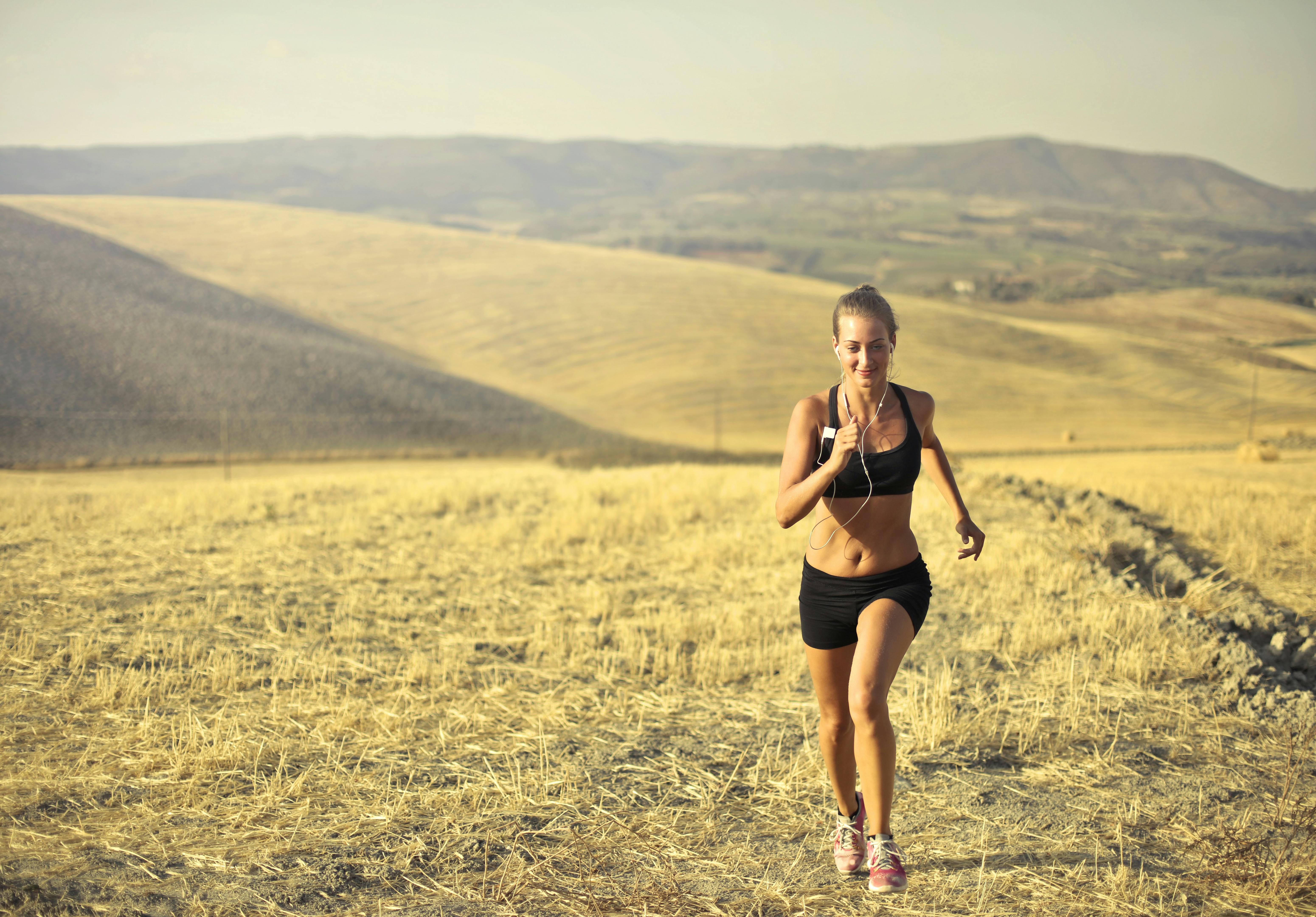 A woman running outdoors, focusing on cardiovascular health and fitness.