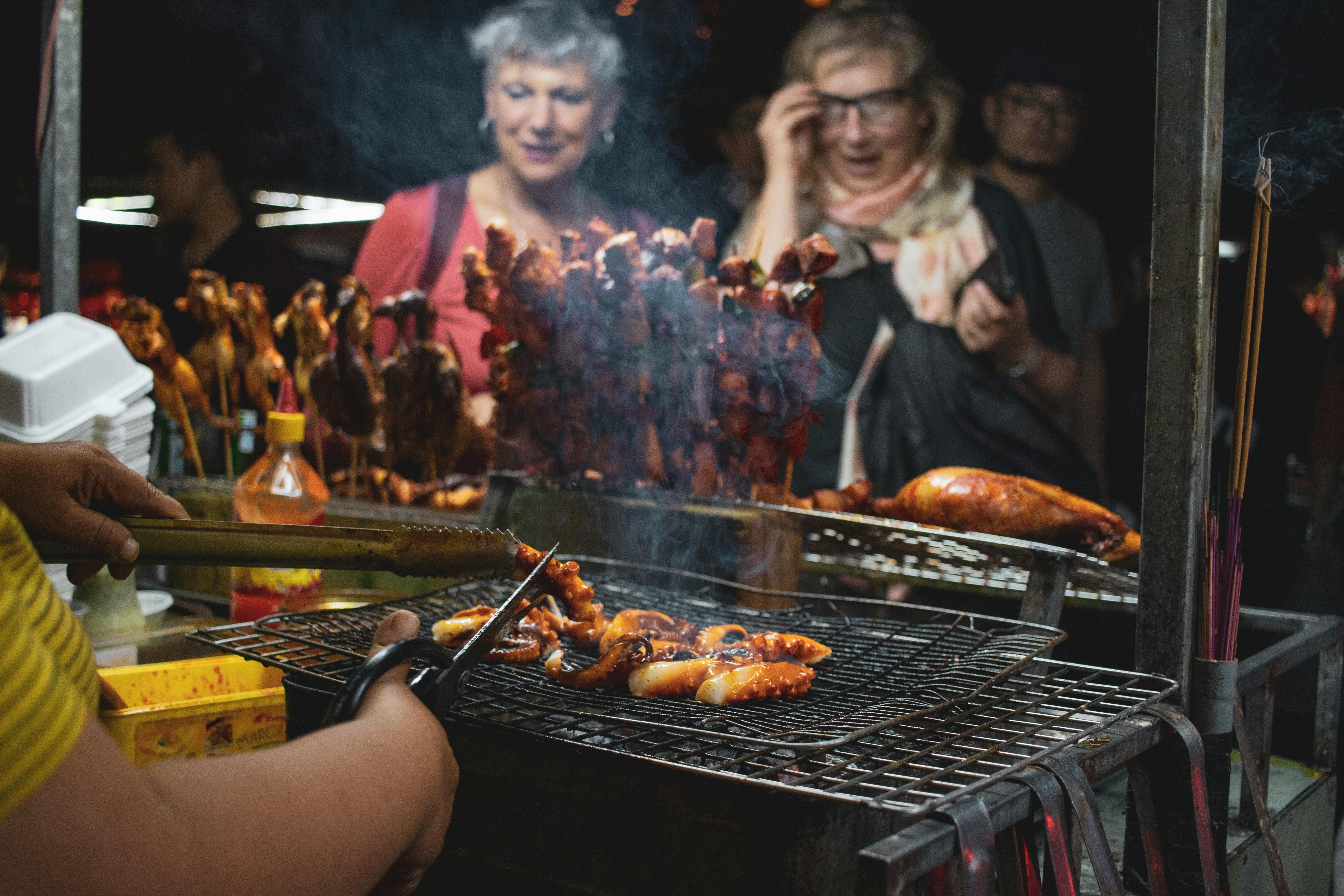 Women enjoying exotic grilled meats and seafood, embracing diverse flavors on the carnivore diet.